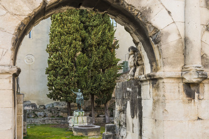 France, Gard, Nimes, Augustus Gate, entrance to the Domitian Way in the city and the reproduction of a statue of the Emperor Augustus in the background