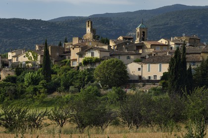 France, Vaucluse (84), Parc Naturel Regional du Luberon, Lourmarin, labellisé Les Plus Beaux Villages de France, la Tour de l'horloge et le chocher de l'église, le massif du Lubéron en arrière-plan