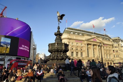 United Kingdom, London, Piccadilly Circus, crowd sitting at the foot of the statue of Eros