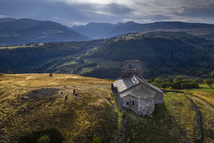 France, Cantal, Parc Naturel Régional des Volcans d'Auvergne (regional nature park of Auvergne volcanoes), Chastel-sur-Murat, 12th century perched on a promontory Saint Antoine (Saint Anthony) Chapel, hickers on the Way of St. James to Santiago de Compostela by Via Arverna (aerial view)