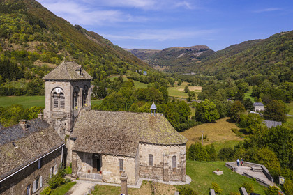 France, Cantal, Parc Naturel Régional des Volcans d'Auvergne (regional nature park of Auvergne volcanoes), Brezons, the Saint Hilaire church from the 11th and 12th centuries, the Brezons valley and the gigantic lava plug of the La Boyle rock in the background (aerial view)