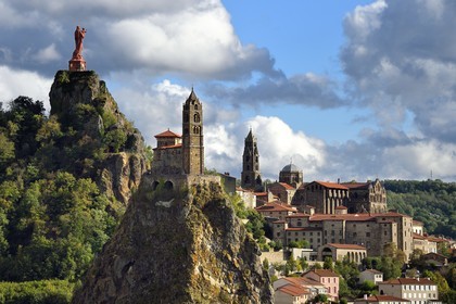 France, Haute Loire, Le Puy en Velay, Routes of Santiago de Compostela in France listed as World heritage by UNESCO, view of the city with the Saint-Michel d'Aiguilhe Chapel perched on a volcanic peak in the foreground, the Notre Dame de France statue (from 1860) on the Rocher Corneille overlooking the 12th century Notre Dame de l'Annonnement cathedral in the background