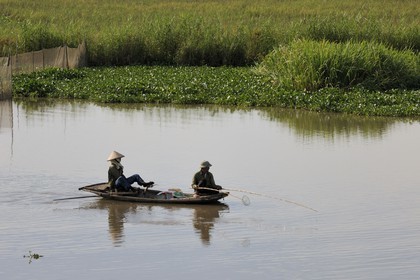 Vietnam, Ninh Binh province, fisherman on a canal, rowing with his feet