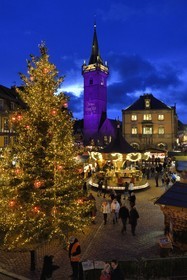France, Bas Rhin, Obernai, Christmas market on the market square, Chapel Tower (Kappelturm) completed in the 16th century, serves as a belfry next to the town hall