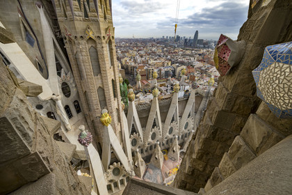 Espagne, Catalogne, Barcelone, quartier de l'Eixample, basilique de la Sagrada Familia de l'architecte du modernisme catalan Antoni Gaudi classée Patrimoine Mondial de l'UNESCO, sommets surmontés de mosaïques en forme de fruits entourant le chantier sur le toit de la nef à l'arrière de la future facade de la Gloire, la Torre Agbar de l'architecte Jean Nouvel en arrière plan