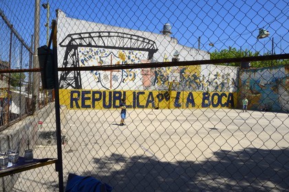 Argentina, Buenos Aires, La Boca district, child playing football in a playground