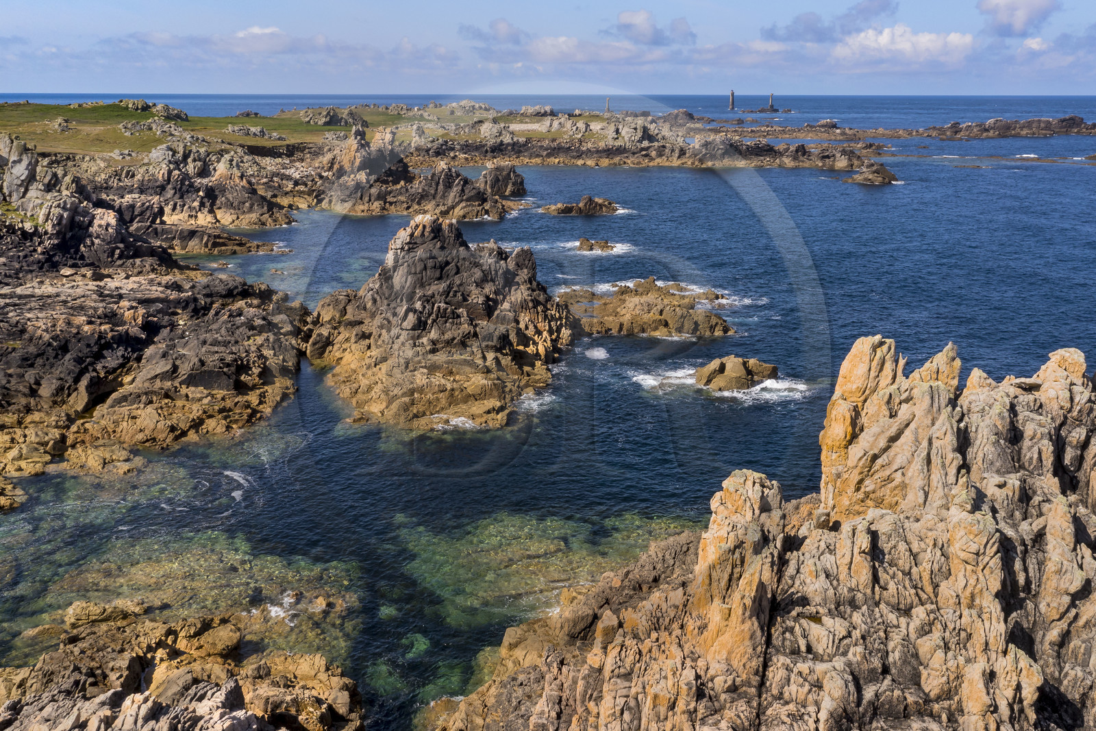 France, Finistère (29), Mer d'Iroise, Ile d'Ouessant, rochers façonnés par les tempêtes au pied du phare du Créac’h, le phare de Nividic sur la Pointe de Pern en arrière plan (vue aérienne)