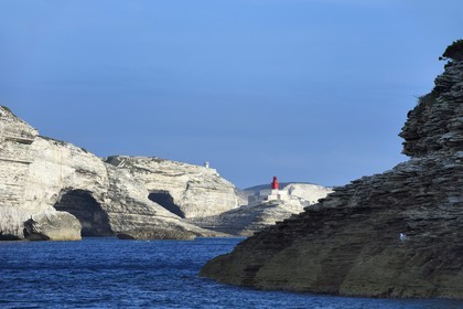 France, Corse-du-Sud (2A), Bonifacio, les falaises de calcaire de plus de 60 mètres de haut et le phare à l'entrée de la calanque