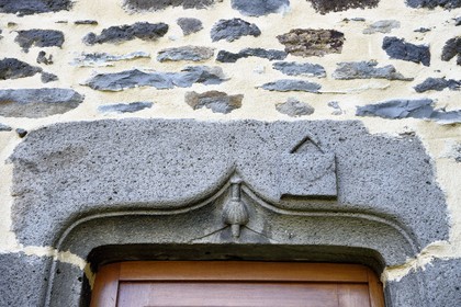France, Cantal, Joursac, carved lintel of the house of a man who made the pilgrimage to Santiago de Compostela, we recognize the top of the bumblebee covered with a shell and the satchel which are symbols