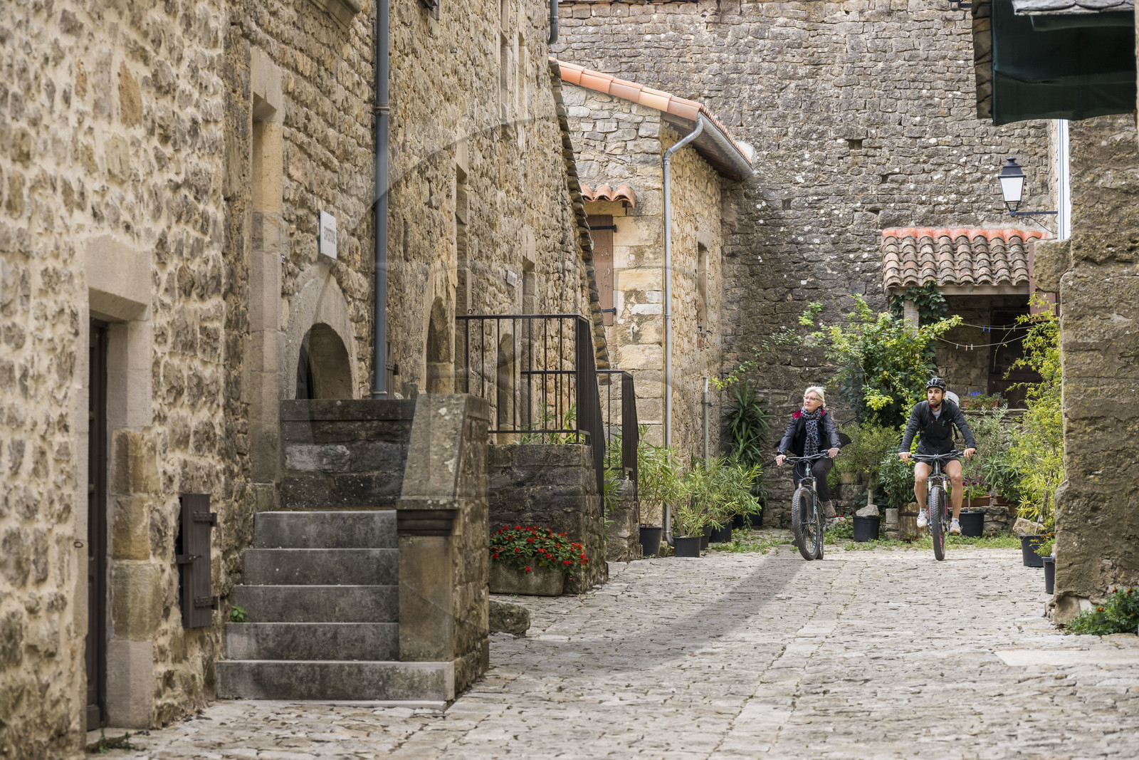 France, Aveyron (12), parc naturel régional des Grands Causses, cyclistes effectuant l'itinéraire cyclo touristique Brebis'Cyclette en Pays de Roquefort, le fort cistercien de Saint-Jean-d’Alcas