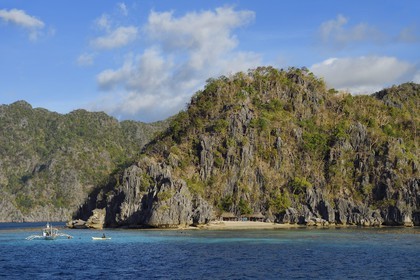 Philippines, Calamian Islands in northern Palawan, Coron Island Natural Biotic Area, Banul Beach under walls of limestone cliffs