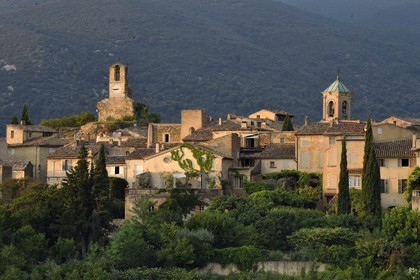France, Vaucluse, Parc Naturel Regional du Luberon (Natural Regional Park of Luberon), Lourmarin, labelled Les Plus Beaux Villages de France (The Most Beautiful Villages of France), the clock tower and the  church bell tower, the massif of Luberon in background