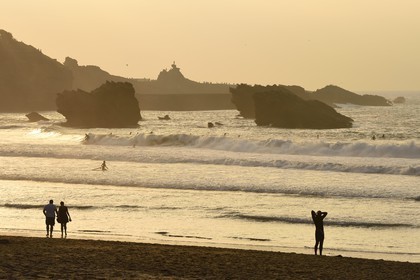 France, Pyrénées-Atlantiques (64), Pays-Basque, Biarritz, surfer à la Grande Plage et le Rocher de la Vierge en arrière plan