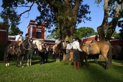Argentine, province de Buenos Aires, San Antonio de Areco, groupe de gauchos à cheval devant l'estancia La Bamba de Areco