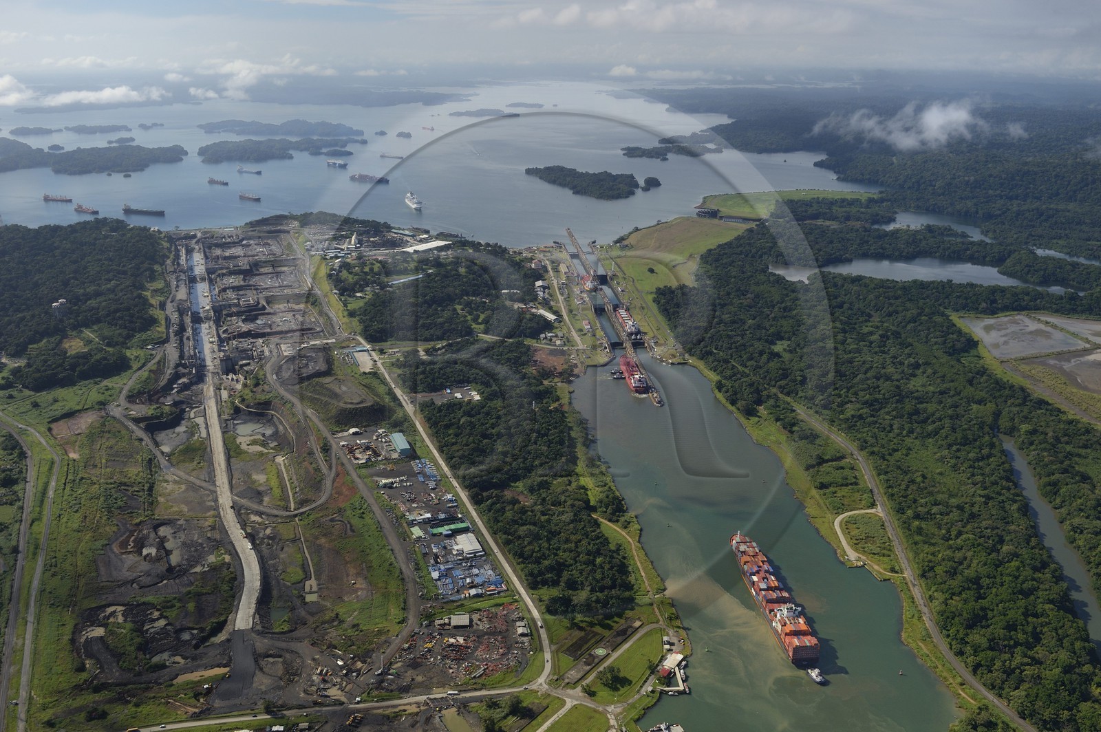 Panama, province de Colon, Canal de Panama, cargo Panamax passant les écluses de Gatun, le chantier des nouvelles écluses sur la gauche et le lac Gatun en arrière plan (vue aérienne)