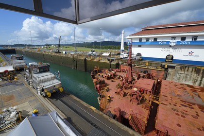 Panama, Colon province, Panama Canal, Gatun locks, mechanical mules or electric locomotives guiding a Panamax cargo between the lock walls