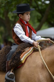 Argentina, Buenos Aires Province, San Antonio de Areco, Tradition Day festival (Dia de Tradition), very young gaucho on horseback in traditional dress during the parade