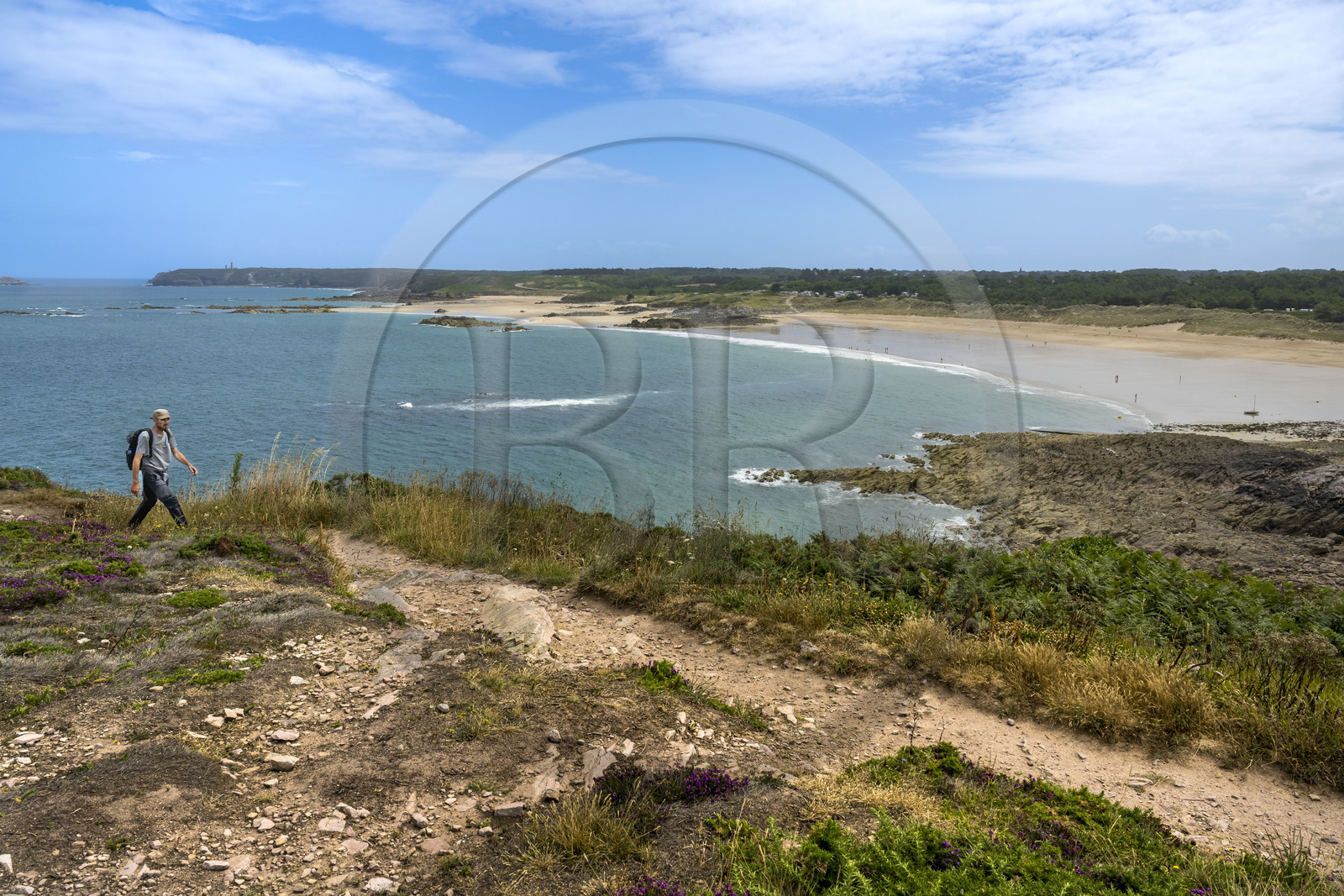 France, Côtes d'Armor (22), Grand Site de France Cap d'Erquy – Cap Fréhel, Fréhel, randonneurs sur le chemin de Grande Randonnée GR34 au dessus de la plage de l'Anse du Croc, le phare du Cap Fréhel en arrière plan