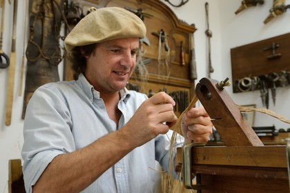Argentine, province de Buenos Aires, San Antonio de Areco, Alejandro Alvarez tresse le cuir des pièces de l'harnachement des chevaux dans son atelier
