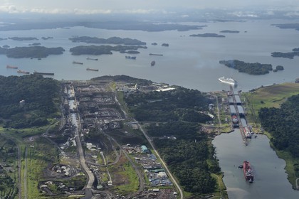 Panama, Colon province, Panama Canal, Panamax cargo passing the Gatun locks, the construction of the new locks on the left and the Gatun Lake in the background (aerial view)