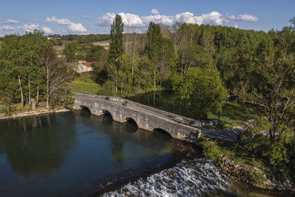 France, Charente, vibrac, the medieval elbow bridge that crosses the Charente river on the route of the Flow Vélo cycle route (aerial view)