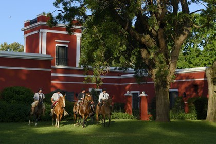 Argentina, Buenos Aires Province, San Antonio de Areco, group of gauchos on horseback in front of the estancia La Bamba de Areco