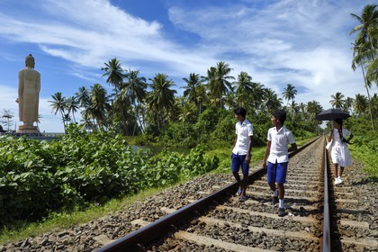 Sri Lanka, Southern Province, Galle district, Telwatta, school children walking on the railway from Colombo to Galle in front of the Peraliya Buddha in memory of the many victims of the crowded train swept away by the tsunami on December 26 2004