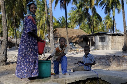 Tanzanie, Zanzibar, côte Sud-Est, famille tirant de l'eau au puit de Pingwe