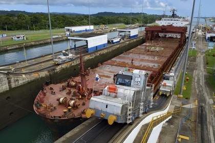 Panama, Colon province, Panama Canal, Gatun locks, mechanical mules or electric locomotives guiding a Panamax cargo between the lock walls
