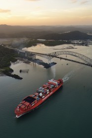 Panama, Panama City, Panama Canal entrance on the Pacific Ocean side, a Panamax container cargo passing under the Bridge of the Americas (Puente de las Americas) (aerial view)