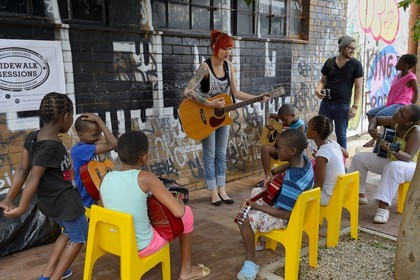 Afrique du Sud, province de Gauteng, Johannesburg, CBD (Central Business District), quartier de Maboneng, Sidewalk Sessions dans Fox street, Kelly Grevler donne des cours de guitare gratuits pour de jeunes enfants dans la rue