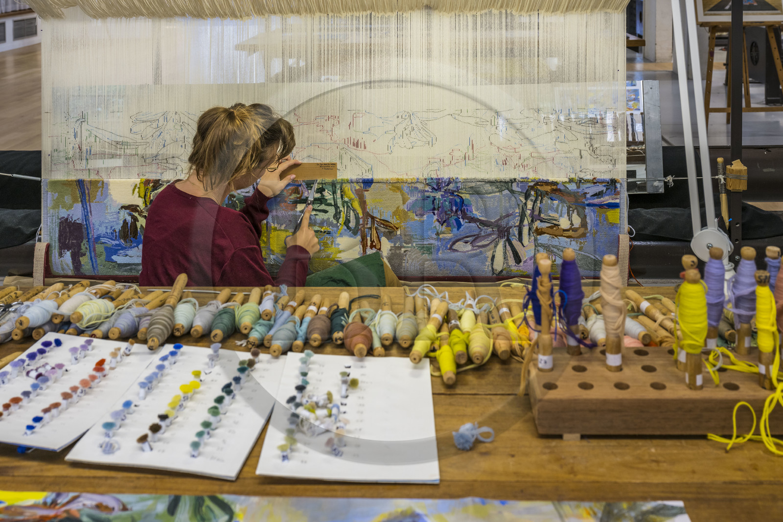 France, Hérault (34), Lodève, Manufacture de la Savonnerie unique annexe de la Manufacture Nationale de tapis de la Savonnerie des Gobelins, réalisation par la licière Kristell Corbinais sur un métier à tisser d'une tapisserie de siège pour banquette L'Iris dans la vallée dessinée par Philippe Borderieux, action de la tonte