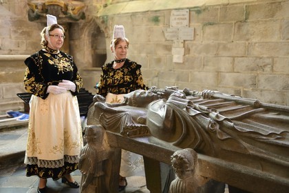 France, Finistere, Locronan, labelled Les plus Beaux Villages de France (The Most Beautiful Villages of France), women in traditional costume during the Tromenie around the cenotaph of St Ronan in Peniti chapel adjacent to the Saint Ronan church