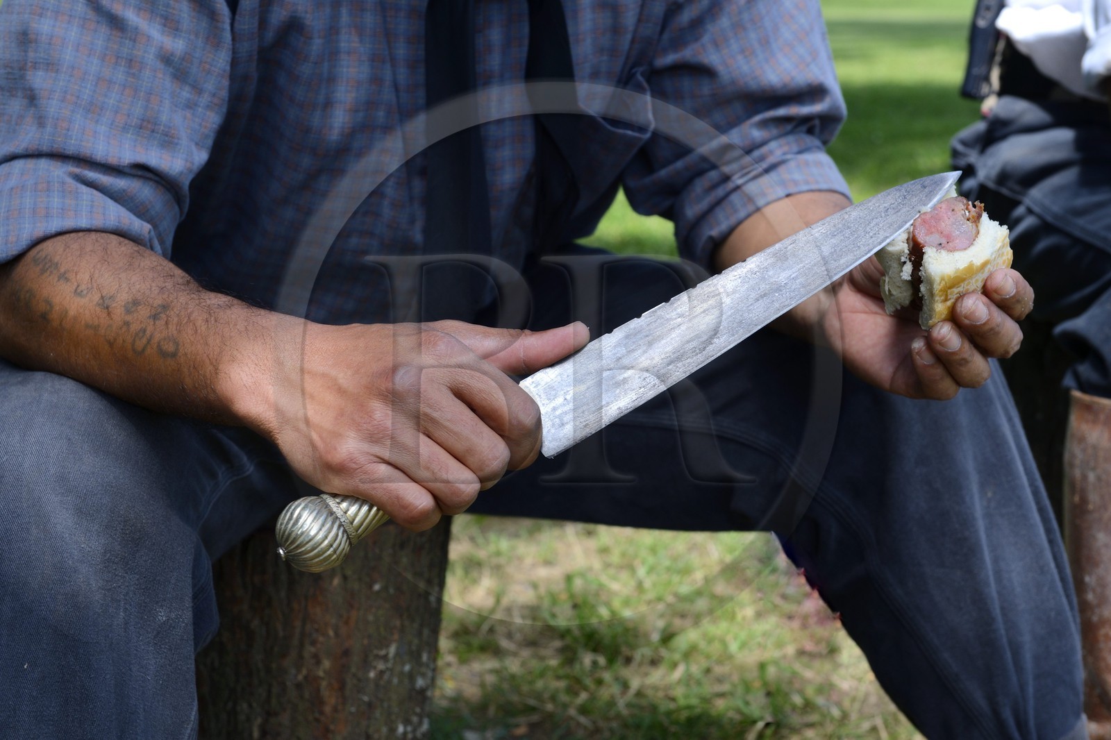 Argentine, province de Buenos Aires, San Antonio de Areco, estancia La Bamba de Areco, gaucho au campement avec son facon (large et long couteau)