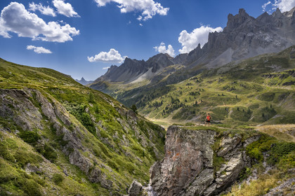 France, Hautes Alpes, Briancon region, Nevache, the upper Clarée valley, hiker with her dogs in the upper Clarée valley, the Cerces massif in the background