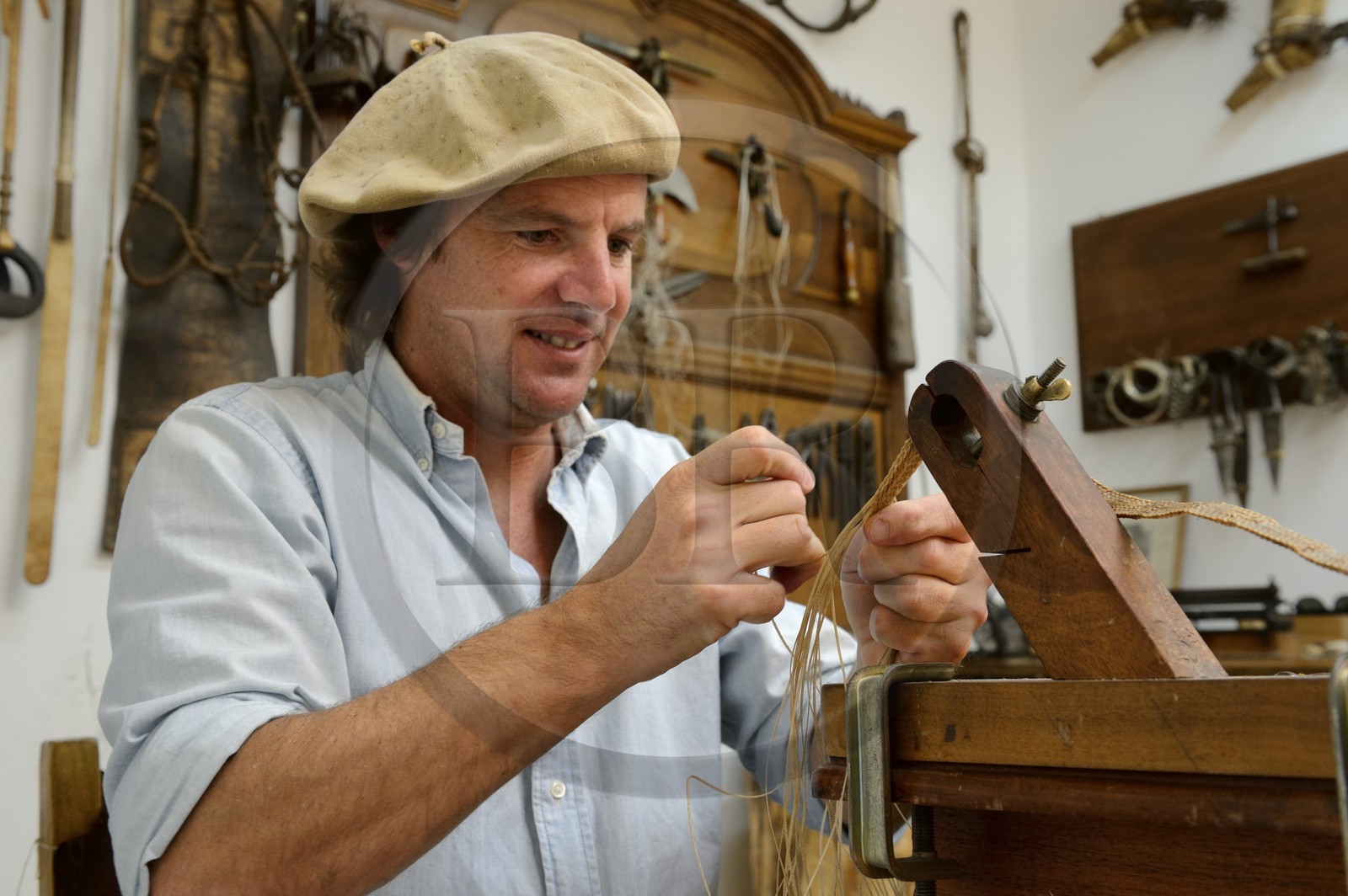 Argentine, province de Buenos Aires, San Antonio de Areco, Alejandro Alvarez tresse le cuir des pièces de l'harnachement des chevaux dans son atelier