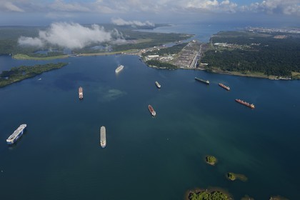 Panama, Colon province, Panama Canal, cargo ships on the Gatun Lake waiting to cross the Gatun Locks, the Limon Bay (Bahia Limon) on the Atlantic side and the city of Colon in the background (aerial view)