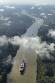 Panama, Panama Canal, a Panamax container cargo uses the Gaillard cut (or Culebra cut) between the Pedro Miguel locks on the Pacific side and the Chagres river leading to Gatun Lake (aerial view)
