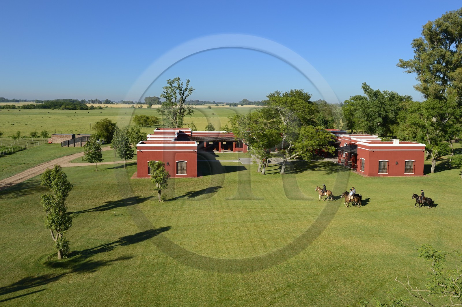 Argentine, province de Buenos Aires, San Antonio de Areco, estancia La Bamba de Areco, gauchos à cheval passant devant l'étable des chevaux utilisés pour le polo