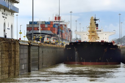 Panama, Panama Canal, Miraflores locks, mechanical mules or electric locomotives guiding a Panamax cargo between the lock walls