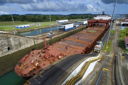Panama, Colon province, Panama Canal, Gatun locks, mechanical mules or electric locomotives guiding a Panamax cargo between the lock walls