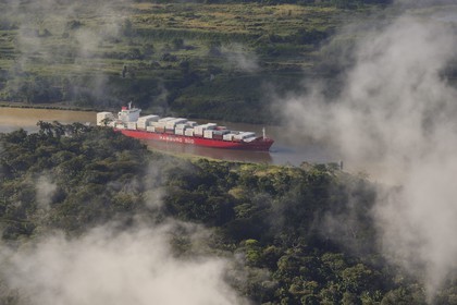 Panama, Panama Canal, a Panamax container cargo uses the Gaillard cut (or Culebra cut) between the Pedro Miguel locks on the Pacific side and the Chagres river leading to Gatun Lake (aerial view)