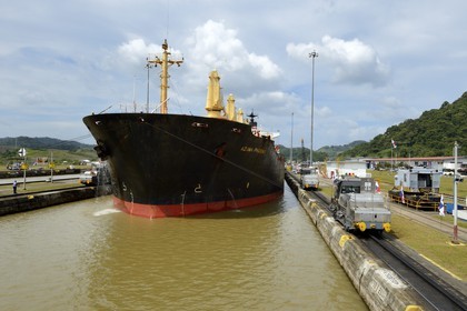 Panama, Panama Canal, Pedro Miguel locks, mechanical mules or electric locomotives guiding a Panamax cargo between the lock walls