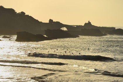 France, Pyrenees Atlantiques, Basque Country, Biarritz, surfer at the Grande Plage (town's largest beach) and the Rocher de la Vierge (Virgin rock) in the background