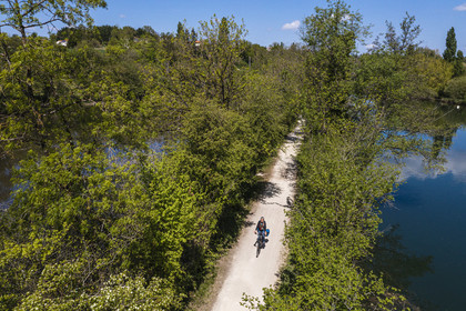 France, Charente, Fleac, a cyclist progresses between two branches of the Charente river on the old towpath which has become La Flow Vélo cycle route (aerial view)