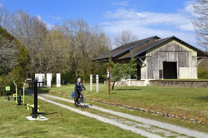 France, Dordogne (24), Périgord Vert, Saint-Jean-de-Côle, labellisé Les Plus Beaux Villages de France, cycliste sur la voie verte de la véloroute Flow Vélo qui emprunte l'ancienne voie de chemin de fer, hangars de l'ancienne gare