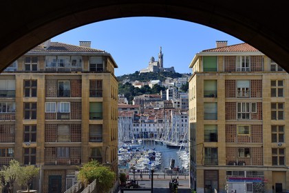 France, Bouches du Rhone, Marseille, the Vieux Port and Notre-Dame de la Garde seen through the buildings of Fernand Pouillon at the bottom of the Panier district