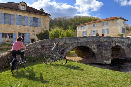 France, Dordogne, Périgord Vert, Saint Jean de Cole labelled Les Plus Beaux Villages de France (The Most Beautiful Villages of France), cyclists doing the Flow Vélo in front of the medieval bridge of the 12th century