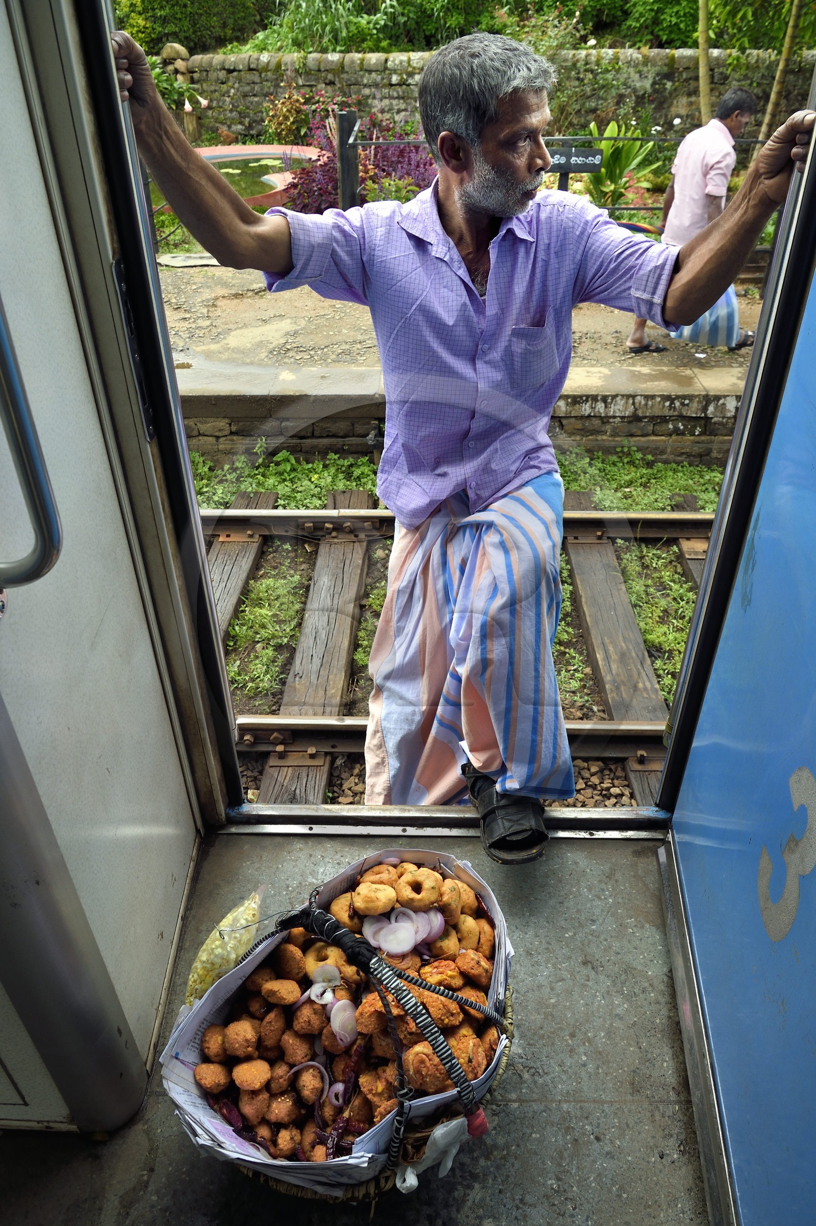Sri Lanka, Province du Centre, trajet en train dans la région montagneuse de la culture du thé entre Hatton et Ella, gare de Talawakele, vendeur ambulant de beignets de crevettes et de wade