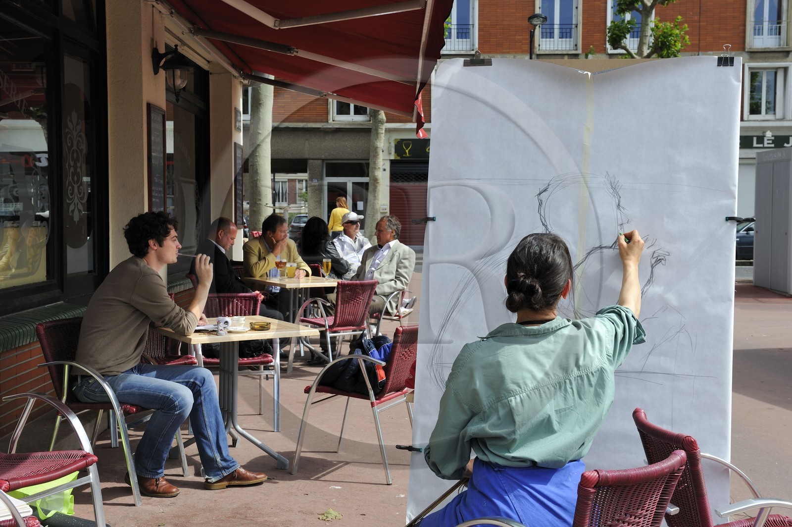 France, Seine-Maritime (76), Le Havre, Centre-ville reconstruit du Havre par Auguste Perret classé Patrimoine Mondial de l'UNESCO, une artiste réalise un portrait pour une exposition sur les quais à une terrasse de café du quartier des pêcheurs